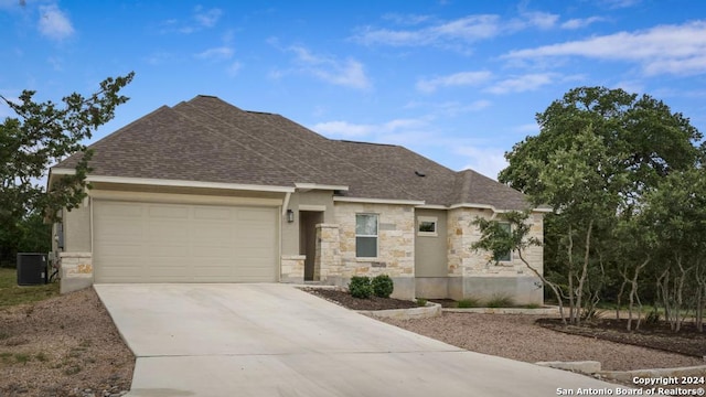 view of front of home featuring a garage and cooling unit