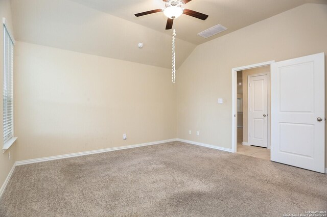 carpeted empty room featuring ceiling fan and vaulted ceiling