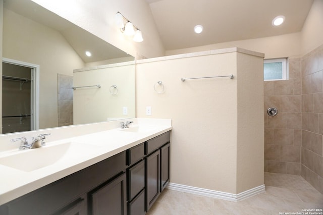 bathroom featuring tiled shower, tile patterned floors, vanity, and vaulted ceiling