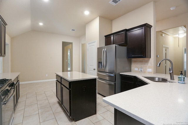 kitchen with sink, stainless steel appliances, vaulted ceiling, decorative backsplash, and a kitchen island