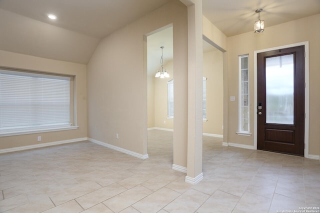 foyer entrance with light tile patterned floors, a chandelier, and lofted ceiling