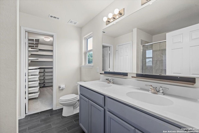 bathroom featuring vanity, an enclosed shower, and toilet