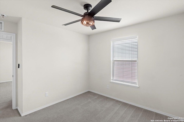 unfurnished room with light colored carpet and ceiling fan