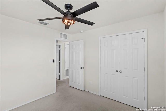 unfurnished bedroom with ceiling fan, a closet, and light colored carpet