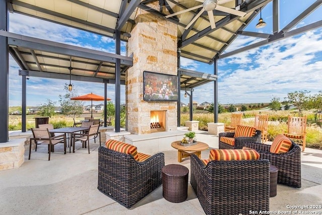 view of patio / terrace featuring an outdoor living space with a fireplace, a gazebo, and ceiling fan