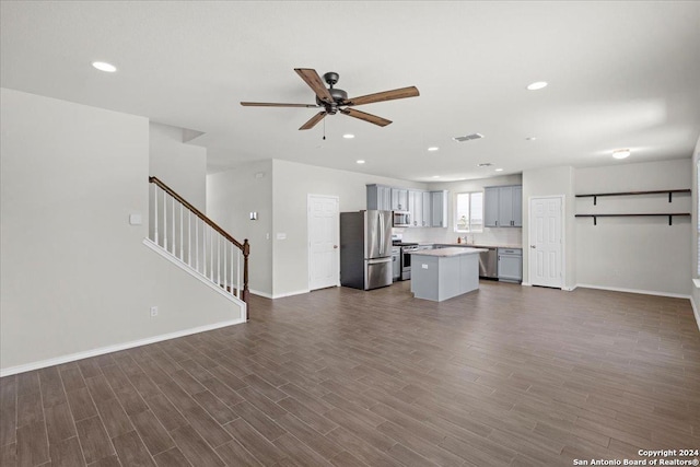 unfurnished living room with ceiling fan and dark wood-type flooring