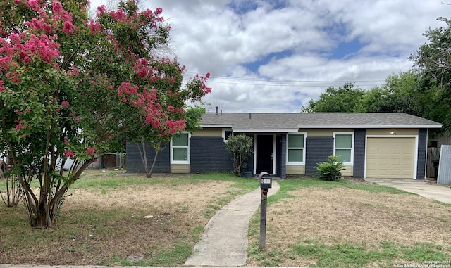 single story home with a front yard and a garage