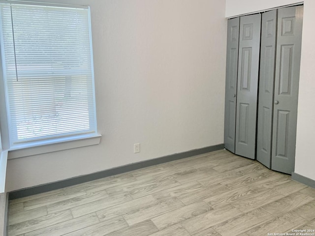 unfurnished bedroom featuring a closet and light hardwood / wood-style flooring