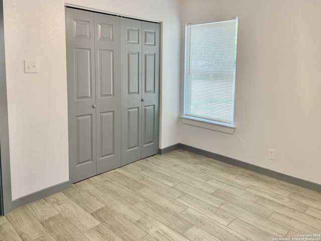 unfurnished bedroom featuring a closet and light hardwood / wood-style flooring