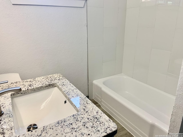 bathroom featuring sink, hardwood / wood-style floors, and a bathtub