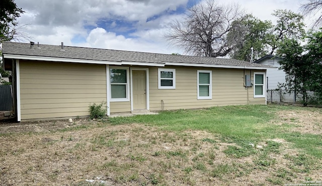 rear view of house featuring a lawn