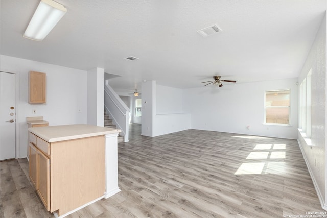 kitchen featuring light brown cabinetry, light hardwood / wood-style flooring, a center island, and ceiling fan