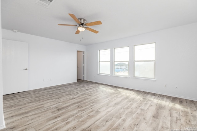 empty room with ceiling fan and light hardwood / wood-style flooring