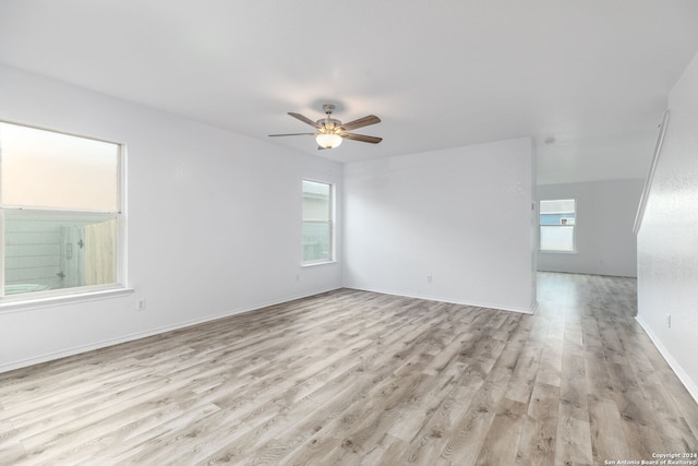 spare room with ceiling fan, light hardwood / wood-style flooring, and a wealth of natural light