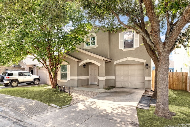 view of property with a garage and a front yard