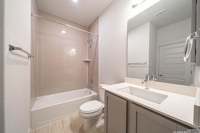 full bath featuring vanity, bathing tub / shower combination, toilet, visible vents, and wood finished floors