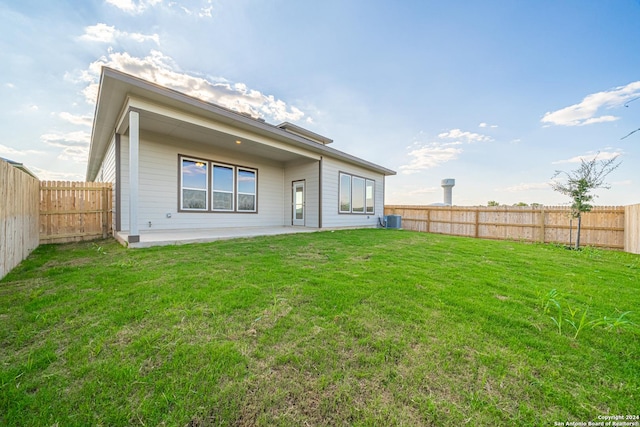 back of house with a patio area, central AC unit, a yard, and a fenced backyard