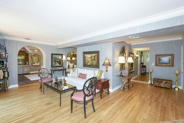 living room featuring light hardwood / wood-style floors, a healthy amount of sunlight, and crown molding