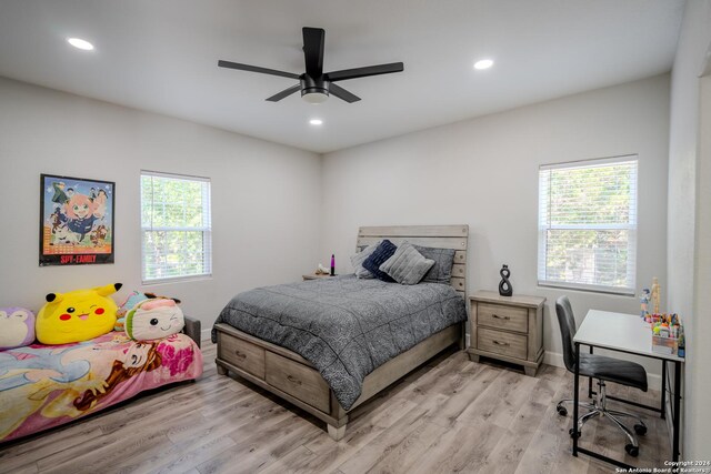 bedroom with ceiling fan, multiple windows, and hardwood / wood-style flooring