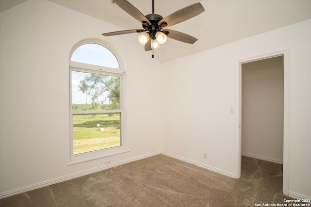 spare room with dark carpet and ceiling fan