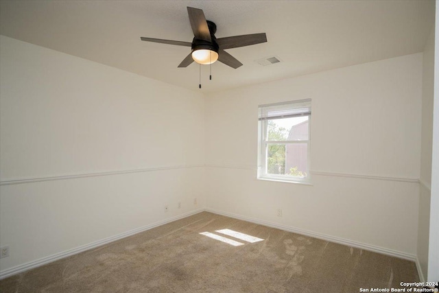 carpeted spare room featuring ceiling fan