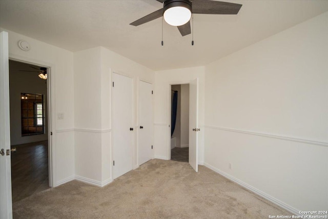 unfurnished bedroom with ceiling fan and light colored carpet