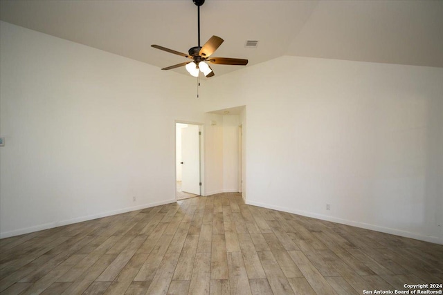 empty room with ceiling fan, light hardwood / wood-style flooring, and vaulted ceiling