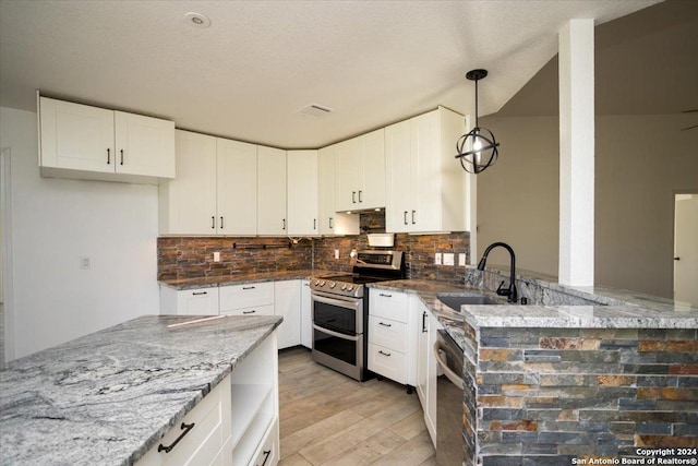 kitchen featuring dark stone counters, range with two ovens, and white cabinetry