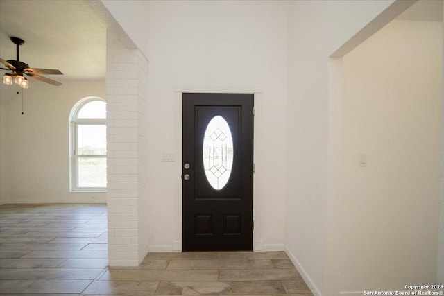 entryway with decorative columns, ceiling fan, and light hardwood / wood-style flooring