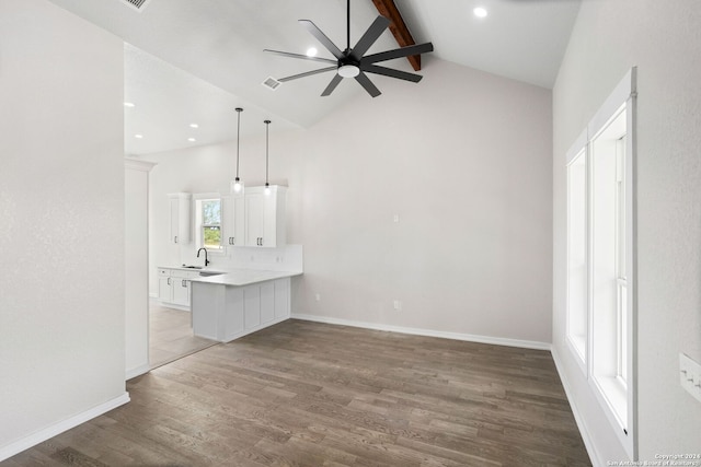 unfurnished living room with ceiling fan, lofted ceiling with beams, and hardwood / wood-style floors