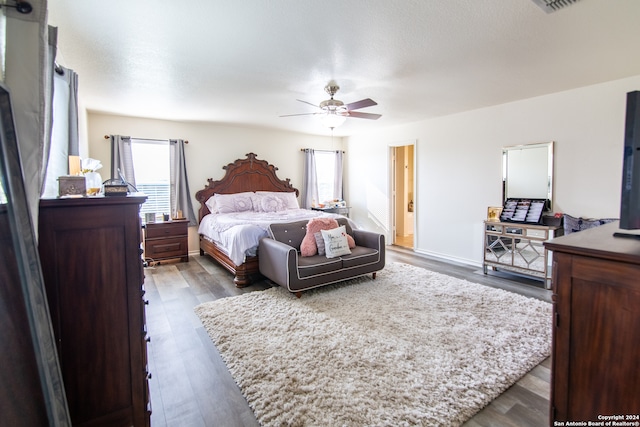 bedroom featuring ceiling fan, hardwood / wood-style floors, and ensuite bathroom