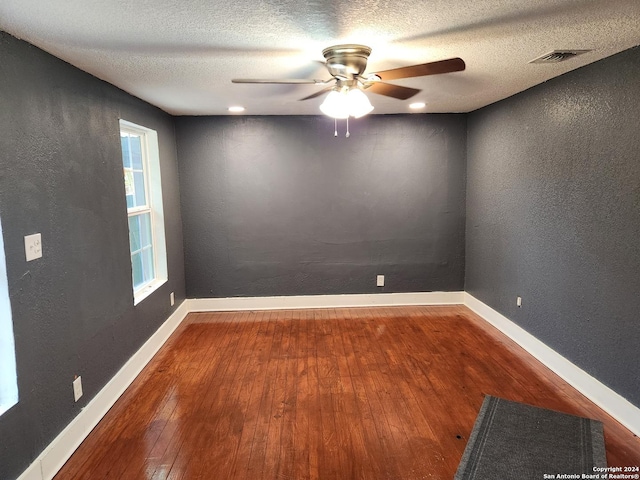 empty room with hardwood / wood-style floors, a textured ceiling, and ceiling fan