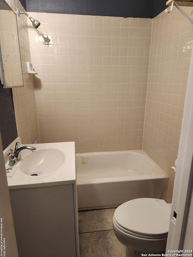 full bathroom featuring tile patterned floors, vanity, tiled shower / bath combo, and toilet