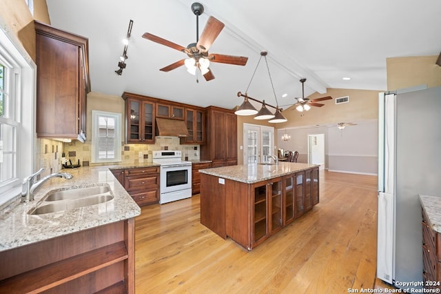 kitchen with electric range, sink, tasteful backsplash, a kitchen island with sink, and custom range hood