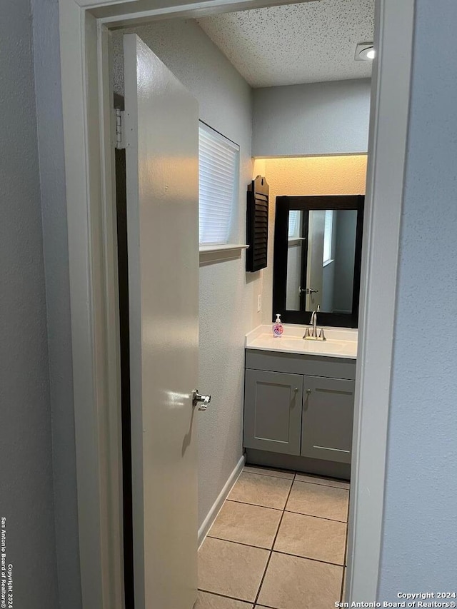 bathroom with tile floors, a textured ceiling, and vanity