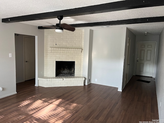 unfurnished living room with brick wall, a brick fireplace, dark hardwood / wood-style flooring, ceiling fan, and a textured ceiling