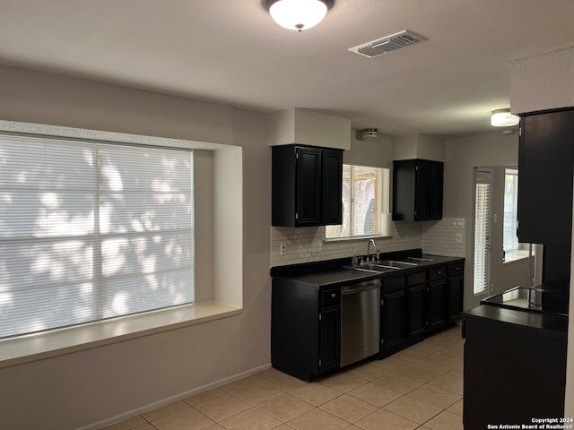 kitchen featuring dishwasher, sink, light tile flooring, and backsplash