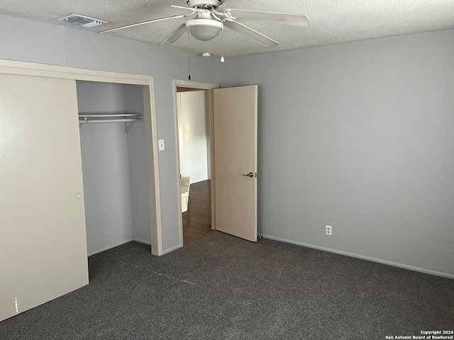 unfurnished bedroom featuring a textured ceiling, a closet, dark colored carpet, and ceiling fan