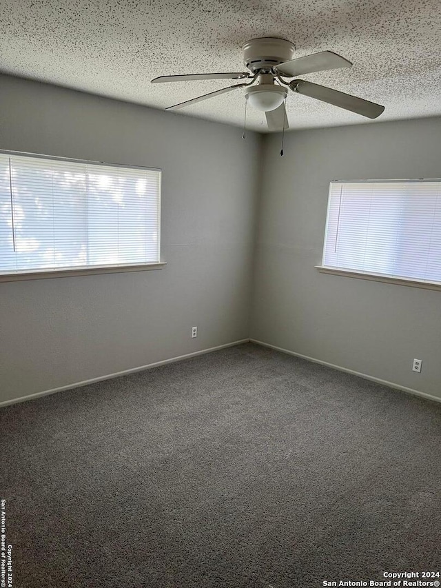 empty room with ceiling fan, a textured ceiling, and carpet flooring