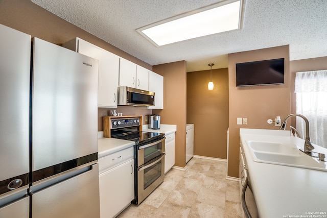 kitchen featuring white cabinetry, pendant lighting, sink, appliances with stainless steel finishes, and light tile patterned floors