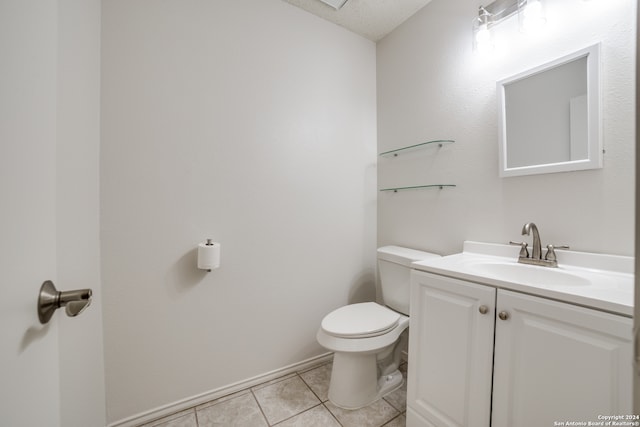 bathroom featuring vanity, tile patterned flooring, toilet, and a textured ceiling