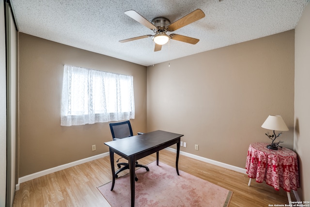 office area with a textured ceiling, ceiling fan, and light wood-type flooring