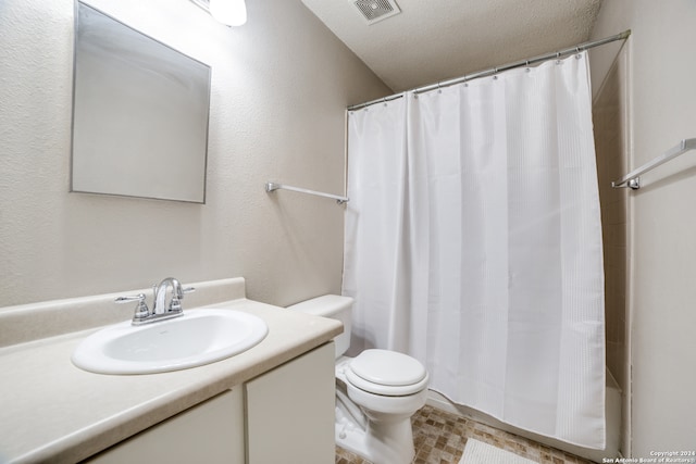 bathroom with vanity, tile patterned flooring, toilet, and a textured ceiling