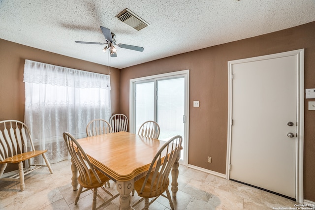 tiled dining area featuring a textured ceiling and ceiling fan