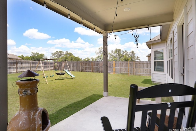 view of yard featuring a playground and a patio