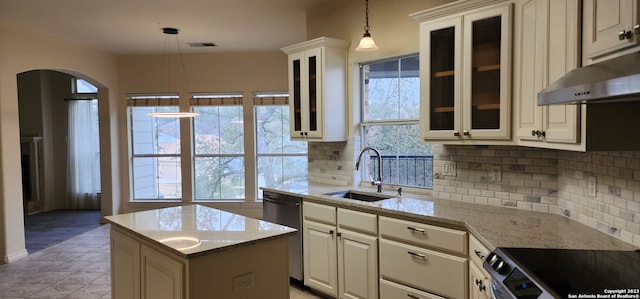 kitchen featuring sink, decorative light fixtures, light tile patterned floors, decorative backsplash, and a center island