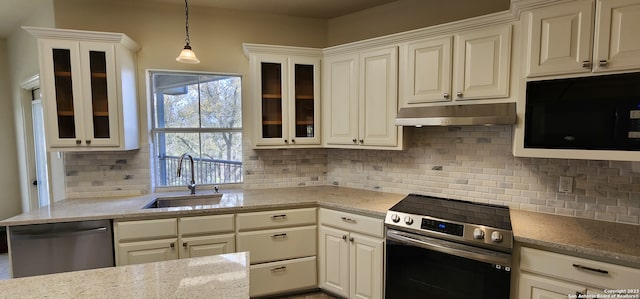 kitchen featuring decorative backsplash, stainless steel appliances, hanging light fixtures, and sink