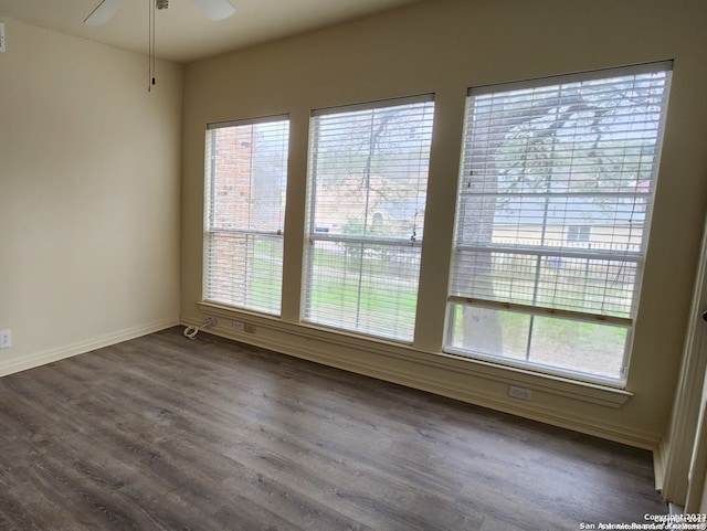 spare room featuring ceiling fan and dark wood-type flooring