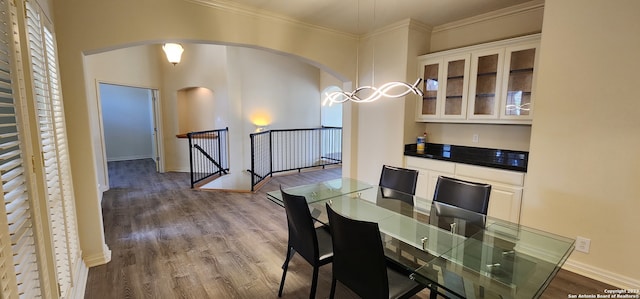 dining space with crown molding and hardwood / wood-style floors