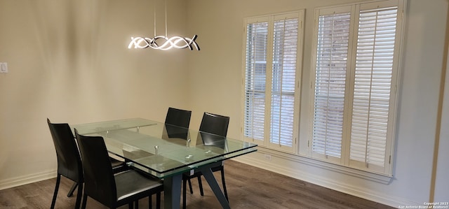 dining space featuring hardwood / wood-style flooring and a chandelier